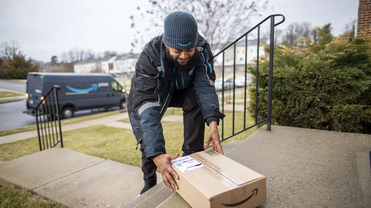 An Amazon worker places a delivery on a residential porch