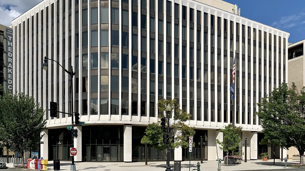 An intersection in Washington, DC, showing two facades of an office building about seven stories tall.