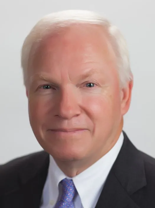 White haired man in dark suit.