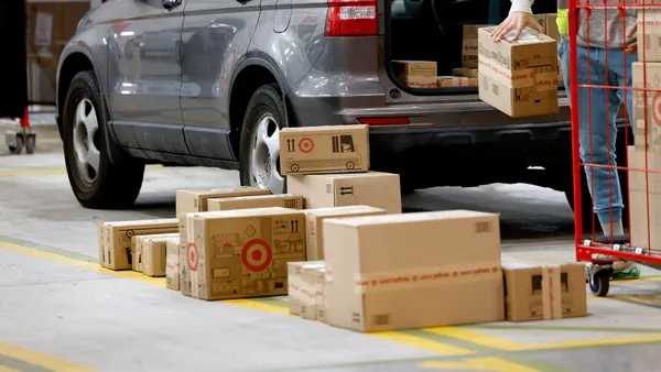 Packages with the Target logo are loaded into a vehicle by a person.