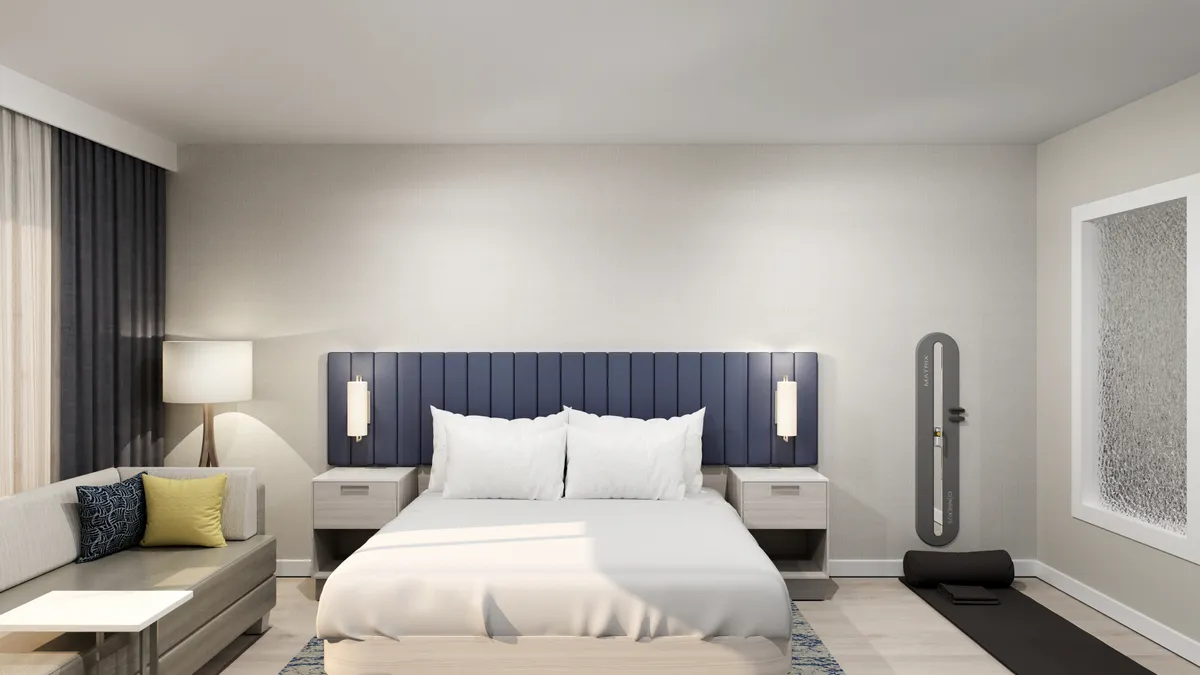 A bed with a white bedspread and navy blue headboard.