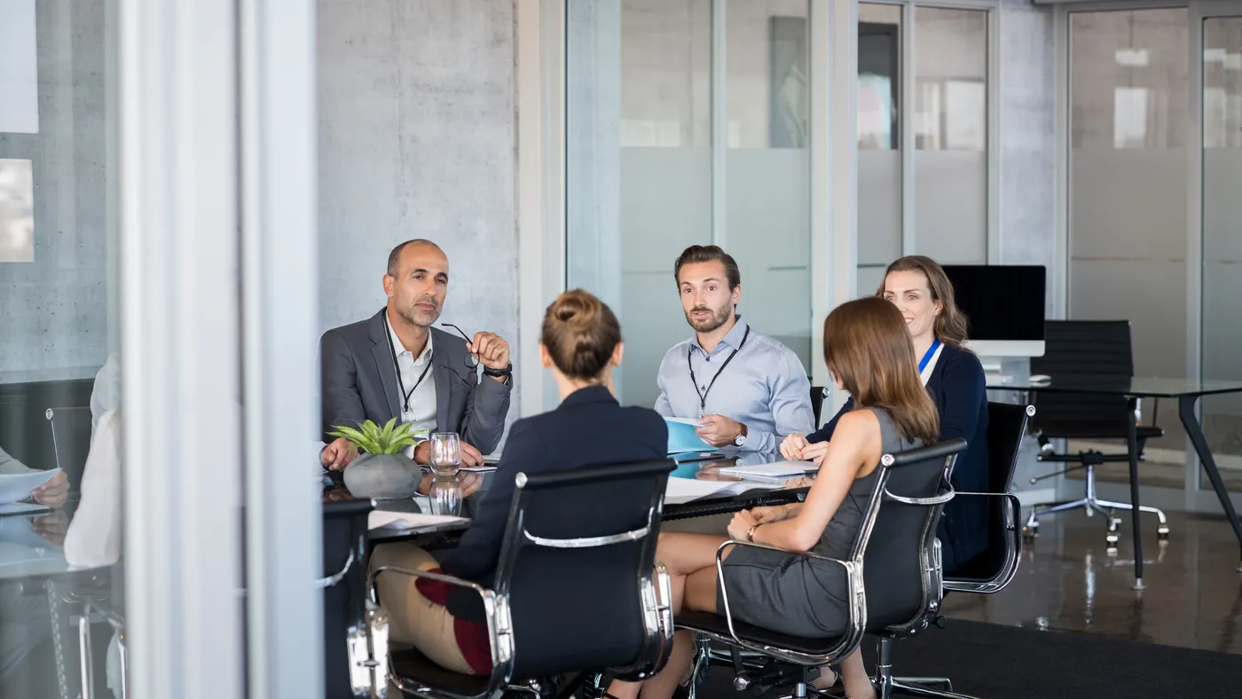 Business people sitting in boardroom and working together at new strategy plan.