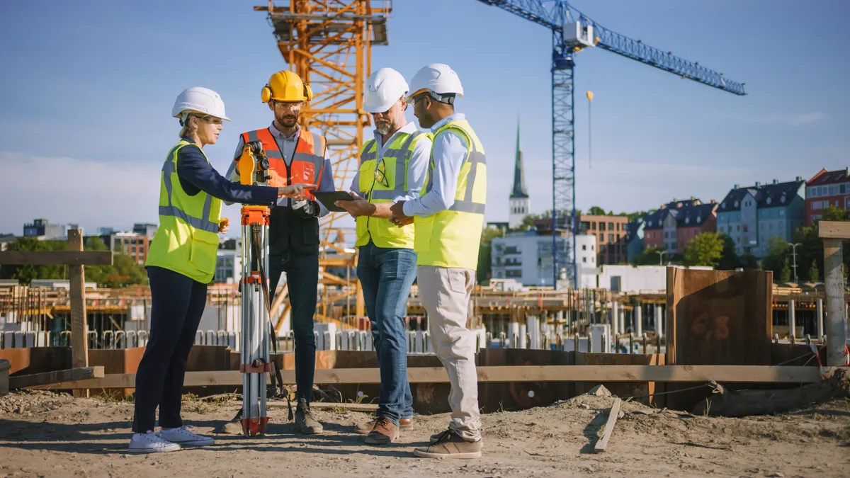 Diverse Team of Specialists Use Tablet Computer on Construction Site