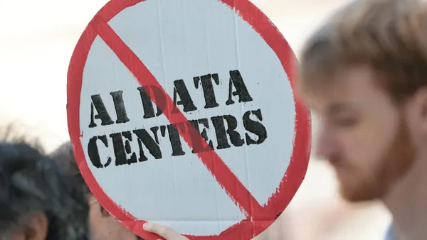 A sign reading "AI Data Centers" with a red line crossing it out.