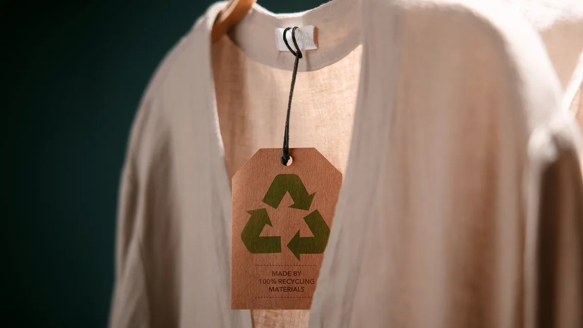 Shirt on a hanger with a recycling tag attached.