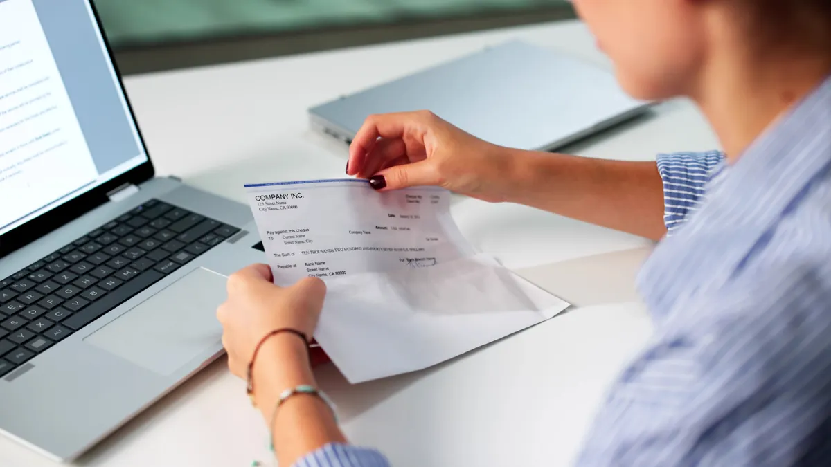 Woman In Office Managing Payroll Compensation Check Envelope