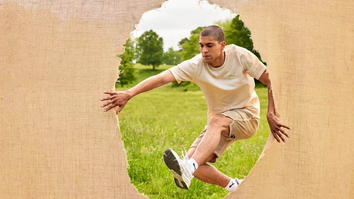 A person steps through a hole in a piece of fabric.