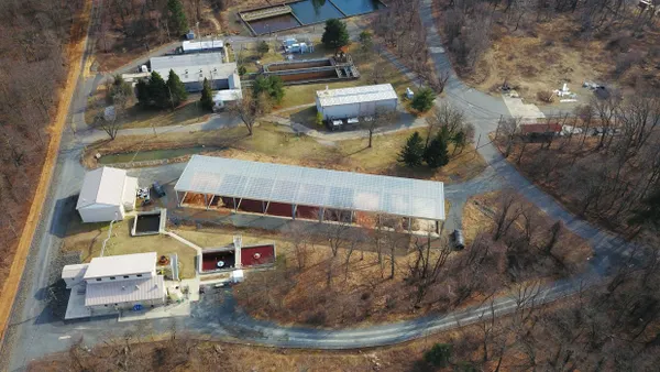 Four white buildings located next to waste management sites