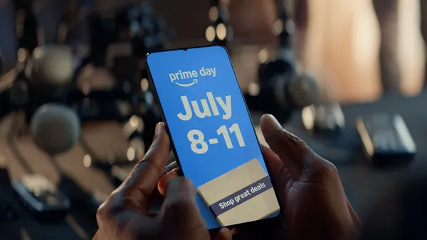 Person holding a phone with Amazon's Prime Day dates.