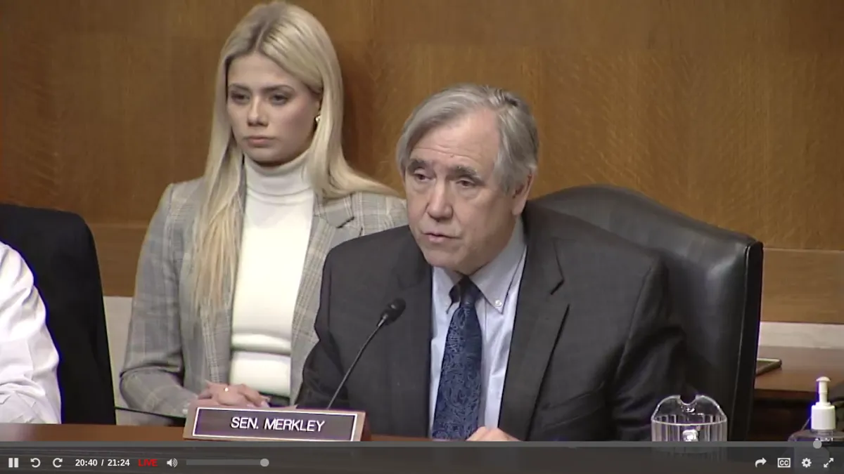 Sen. Jeff Merkley speaks into a microphone at a Senate committee hearing