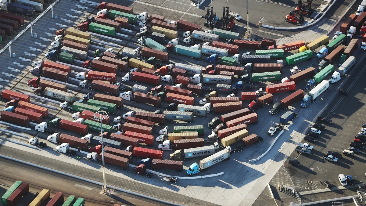 Trucks wait at a gate outside a Port of Los Angeles terminal.