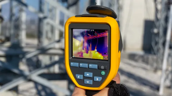 An infrared thermal imaging camera pointing at an electrical transformer.