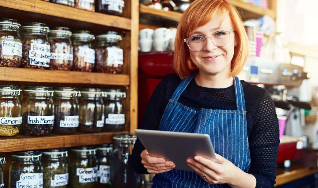 Barista holding a tablet for coffee shop.