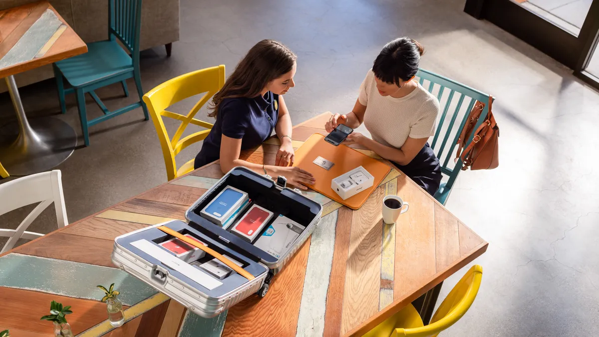 An Enjoy Technology worker assisting a customer set up a smartphone