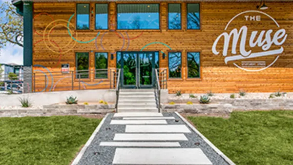 Entrance to an apartment property with the words "The Muse" on the building.