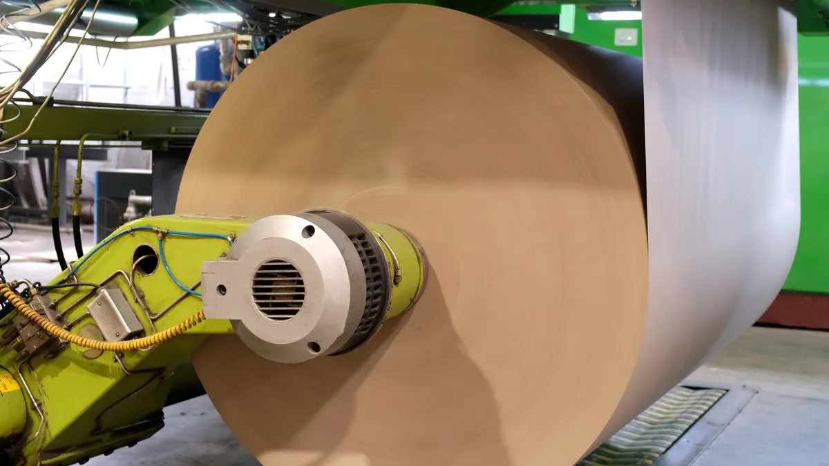 A large roll of kraft paper in a factory setting