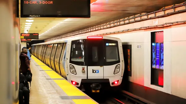 A sleek train approaches a shiny subway platform.