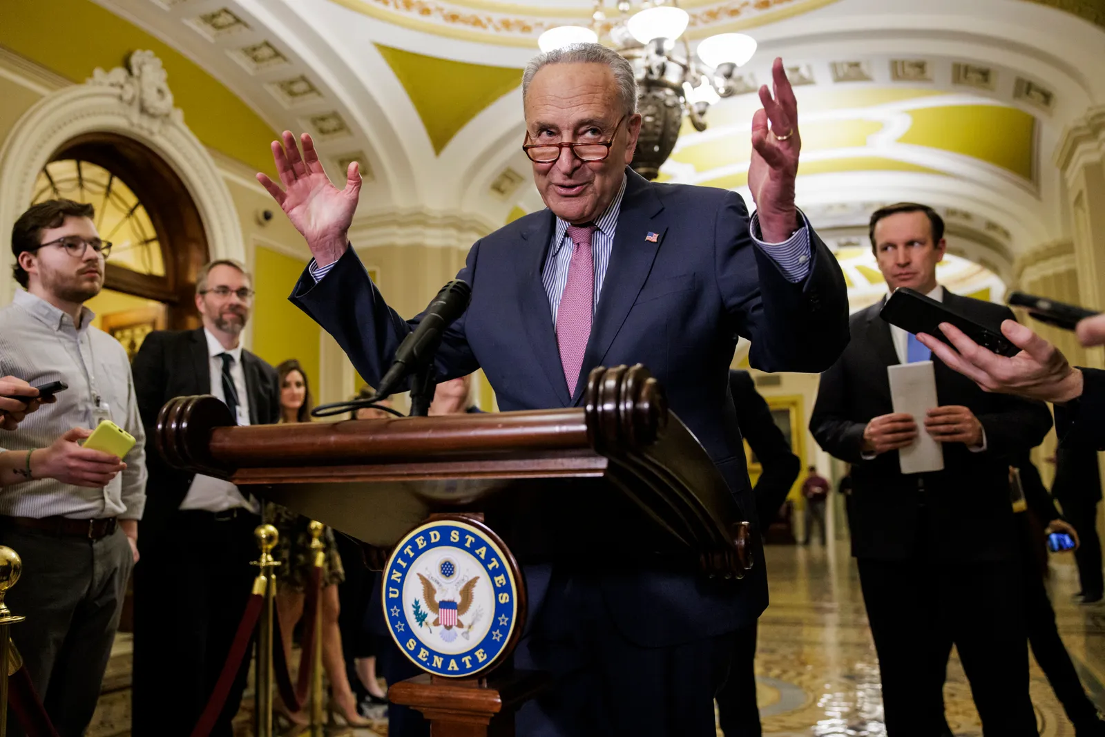 Senate Majority Leader Chuck Schumer on a podium giving a press conference.