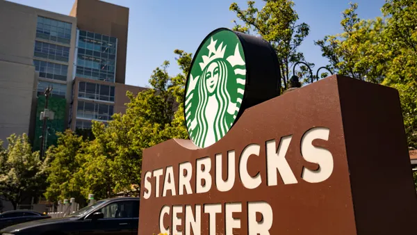 A photograph of a brown sign with white lettering that says Starbucks Center.