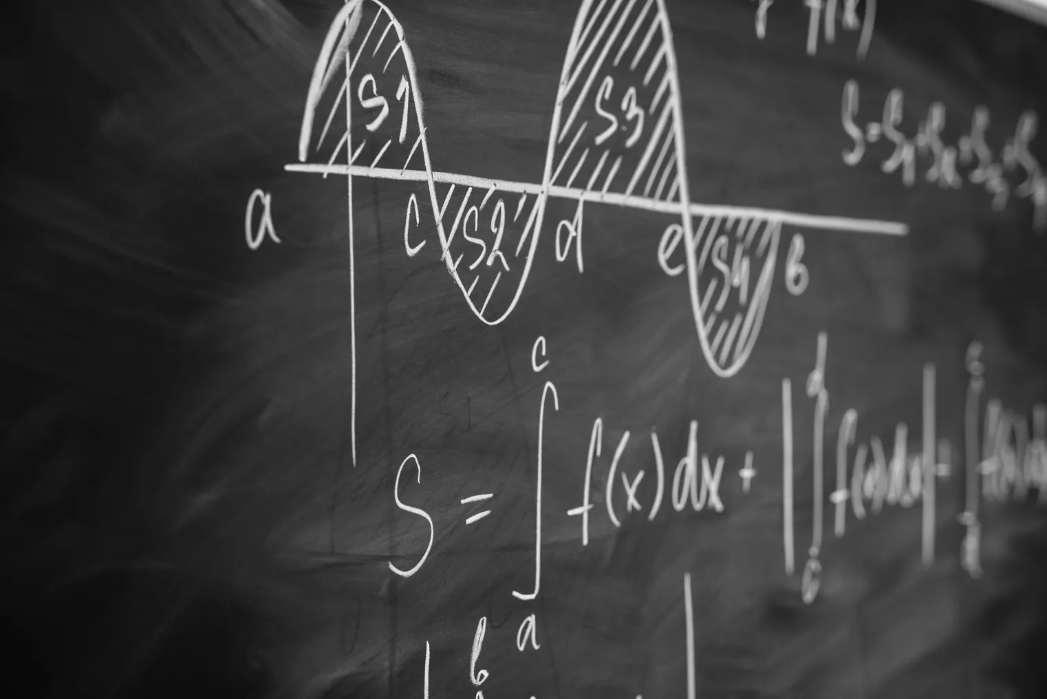 Calculus equations are shown written in white on a blackboard.