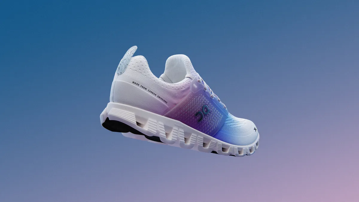 A white, blue and purple running shoe by the brand On