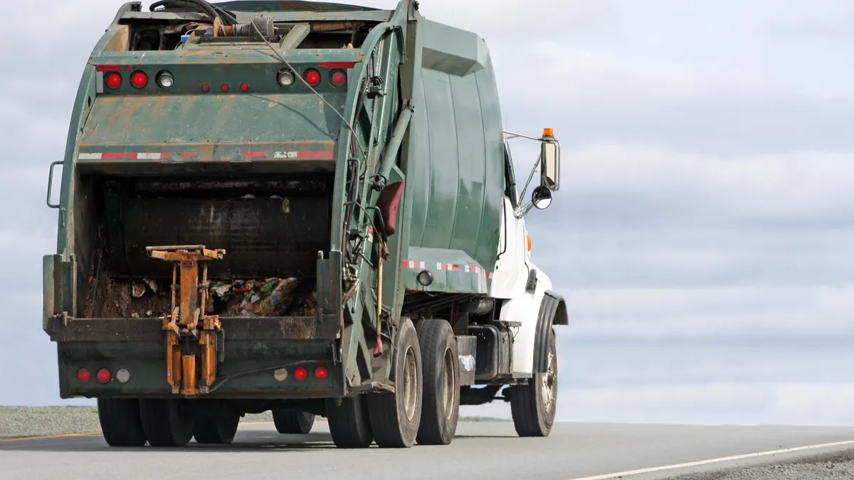 A waste management truck hauls another load of solid waste to a landfill site.