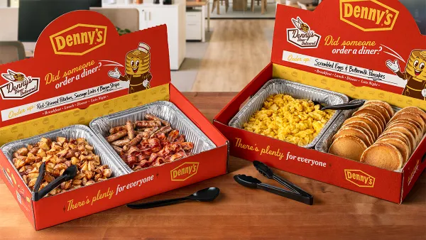 A photograph of two boxes on a table with various breakfast food items in aluminum pans.