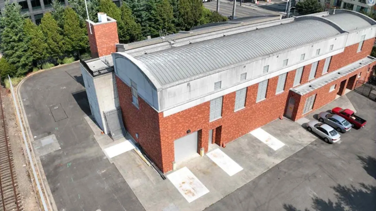 Aerial view of a brick building with a metal roof.