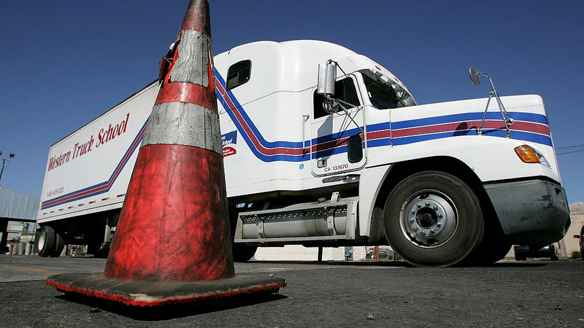 A semi-truck manuevers around a traffic cone during training at the Western Trucking School August 3, 2005 in Turlock, California.