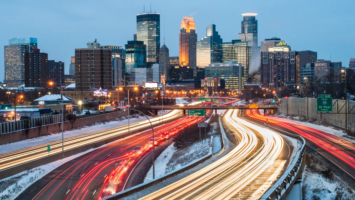 City skyline in background, snowy highways in foreground