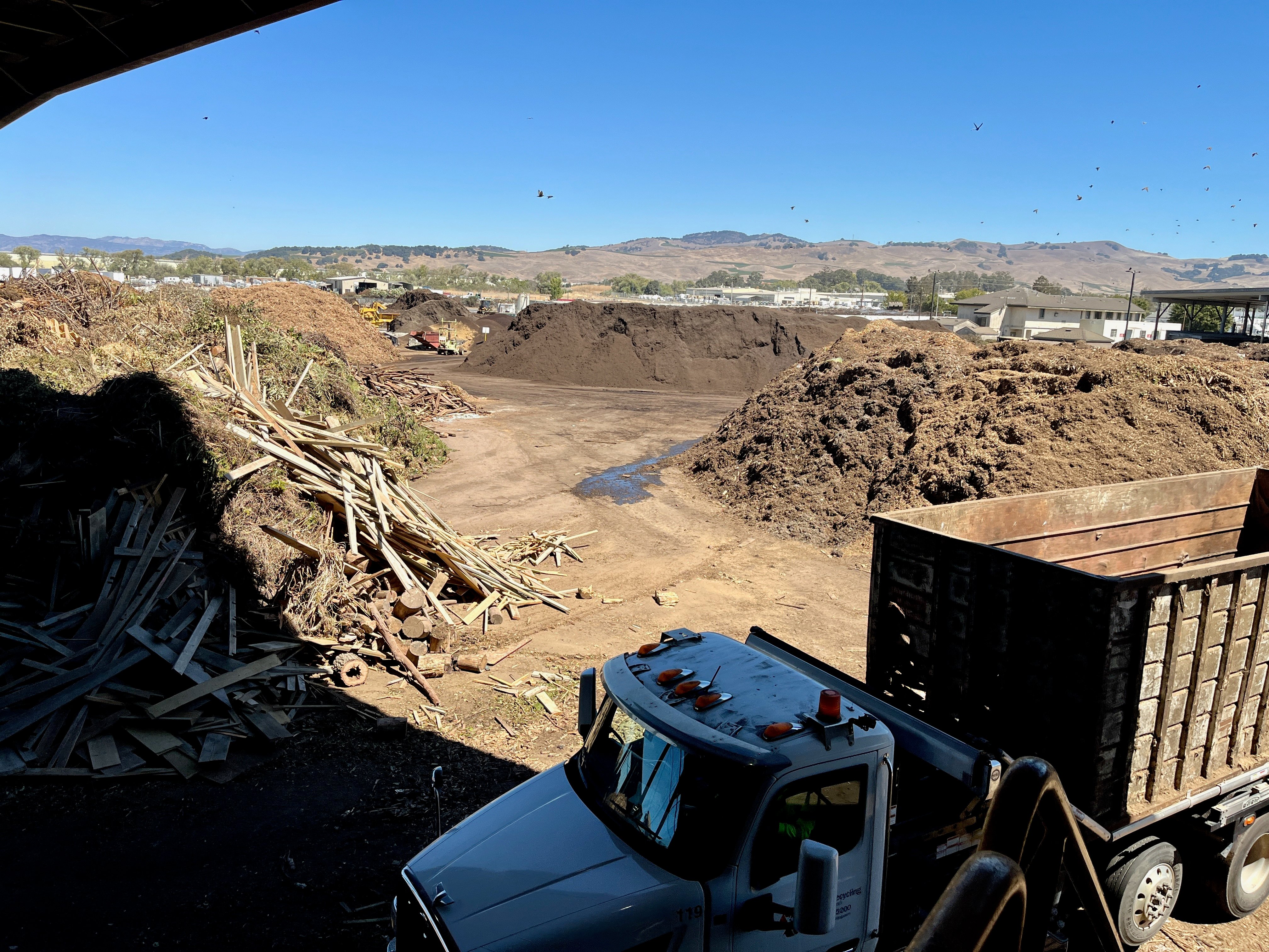 Image of California composting equipment and truck, with mountains in background