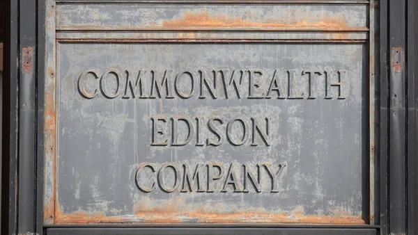 An old, worn, gray stone sign that says "Commonwealth Edison Company" is seen.