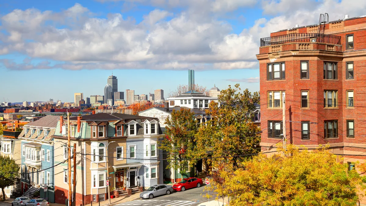 Housing on a residential street with city skyline in background.