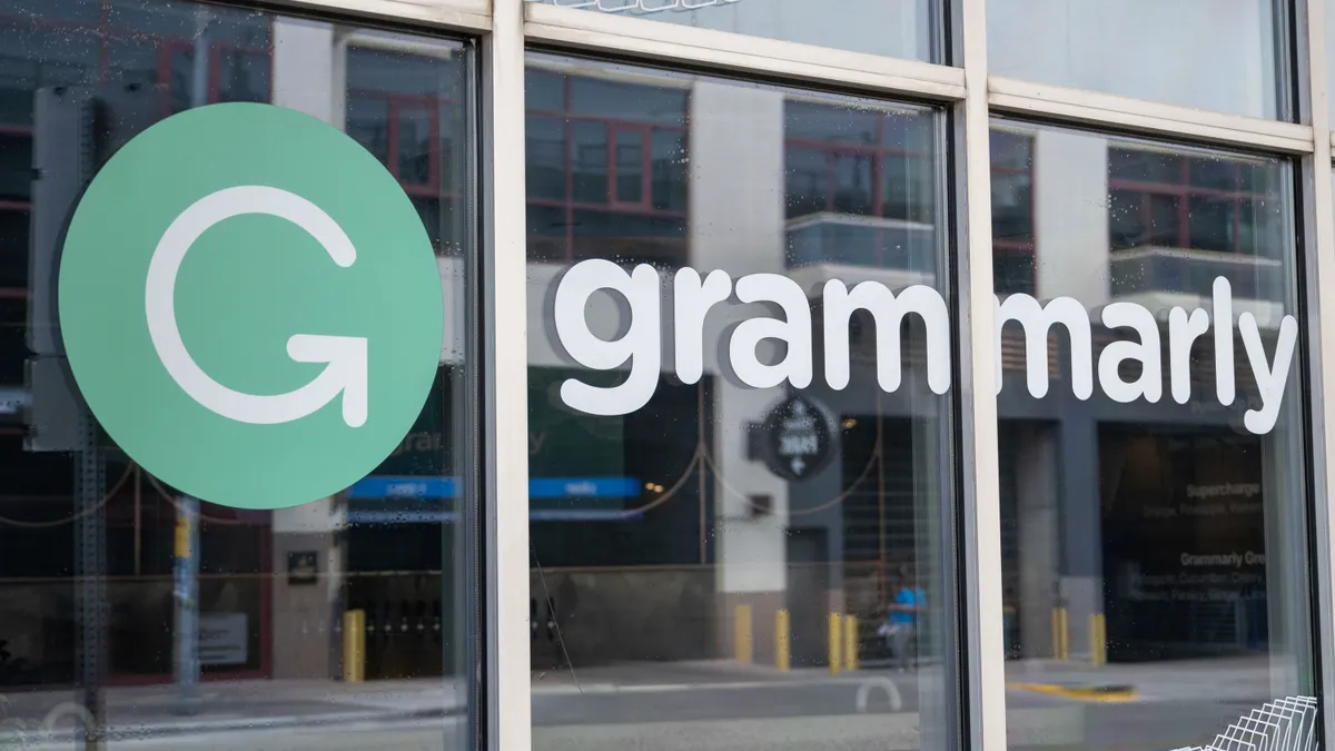 The green and white Grammarly signage is seen on the outside a window front.