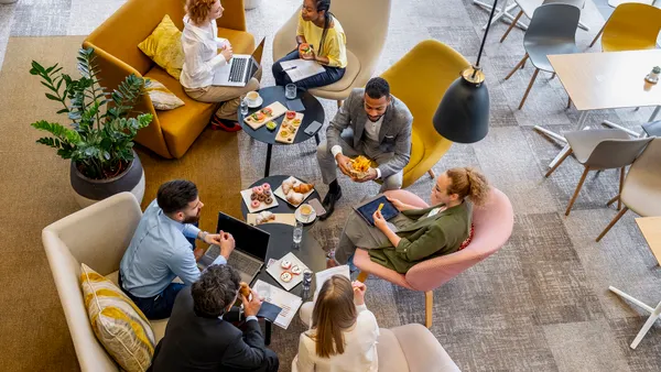 Business people having a brunch meeting in office chairs.