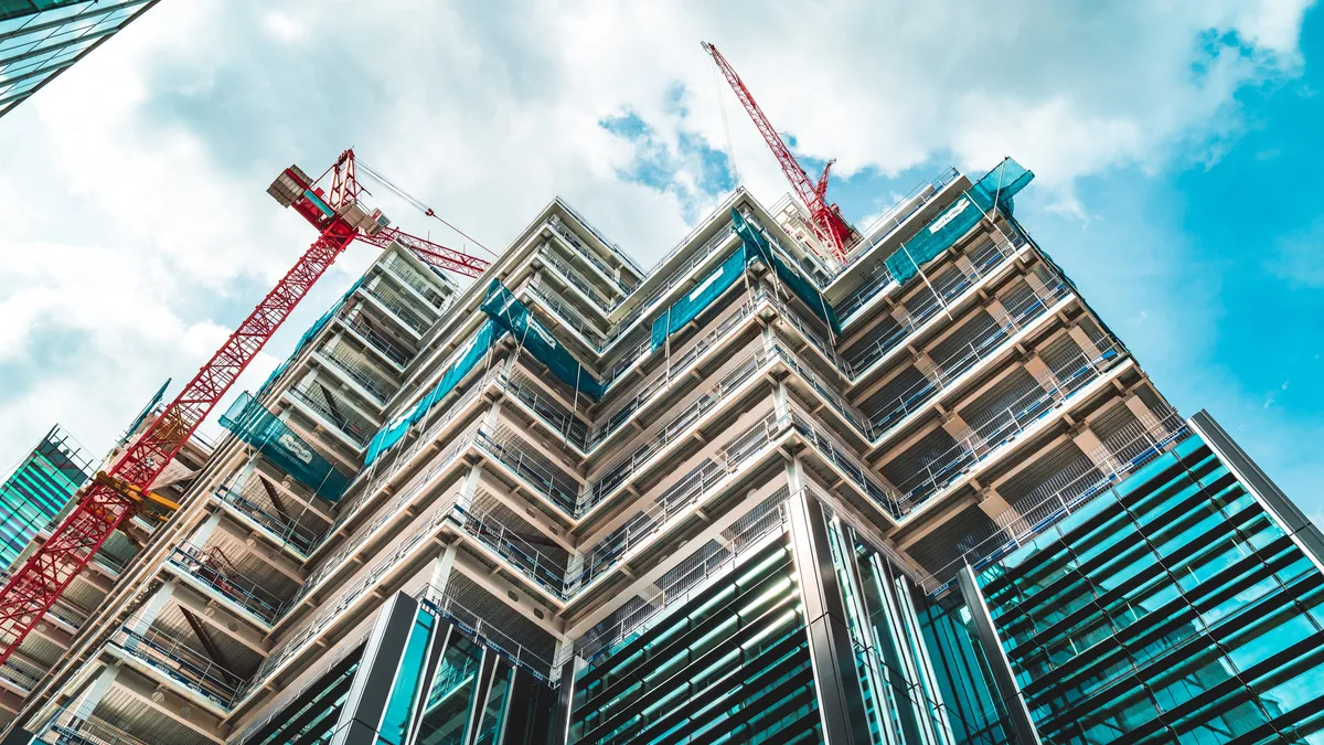 A tall building under construction rises to the sky.