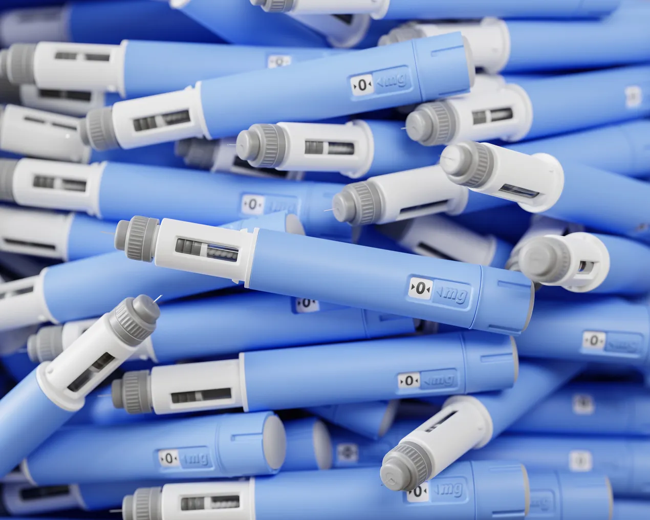 A large group of dosing pens for subcutaneous injection of anti-obesity medication piled in a heap.