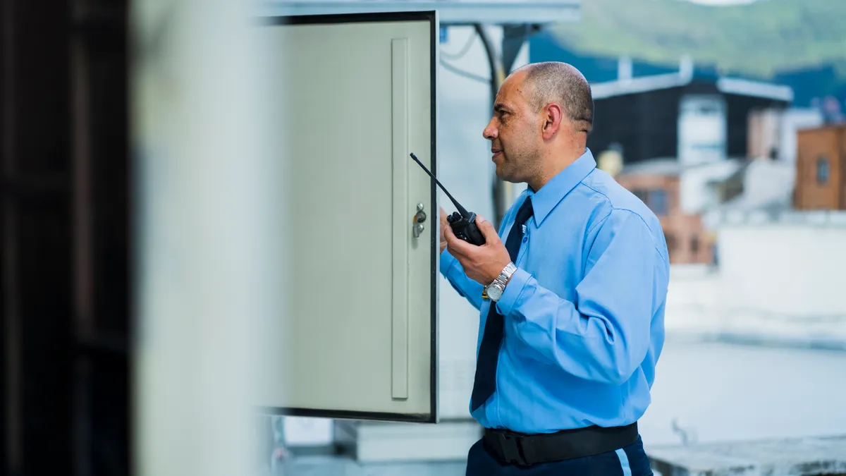 A facility manager looks at a building panel.