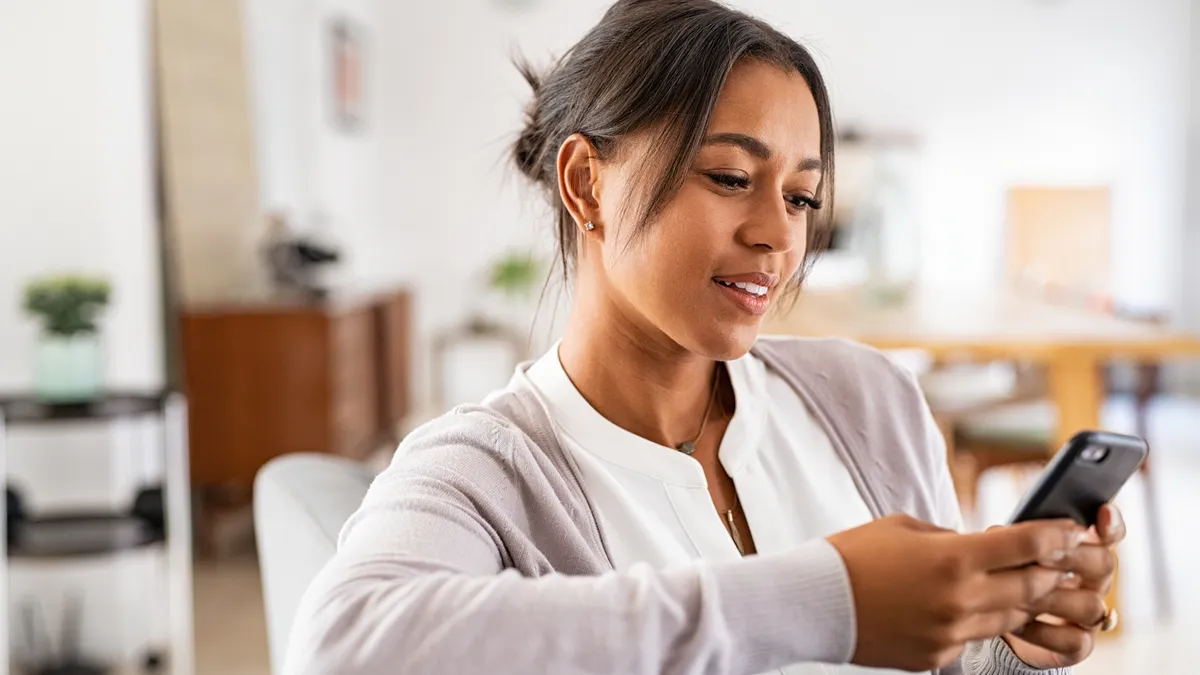 A freelance lawyer checks a mobile app on her phone