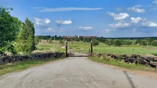 A road leads to a fenced-off green area in Franklin County, Arkansas.