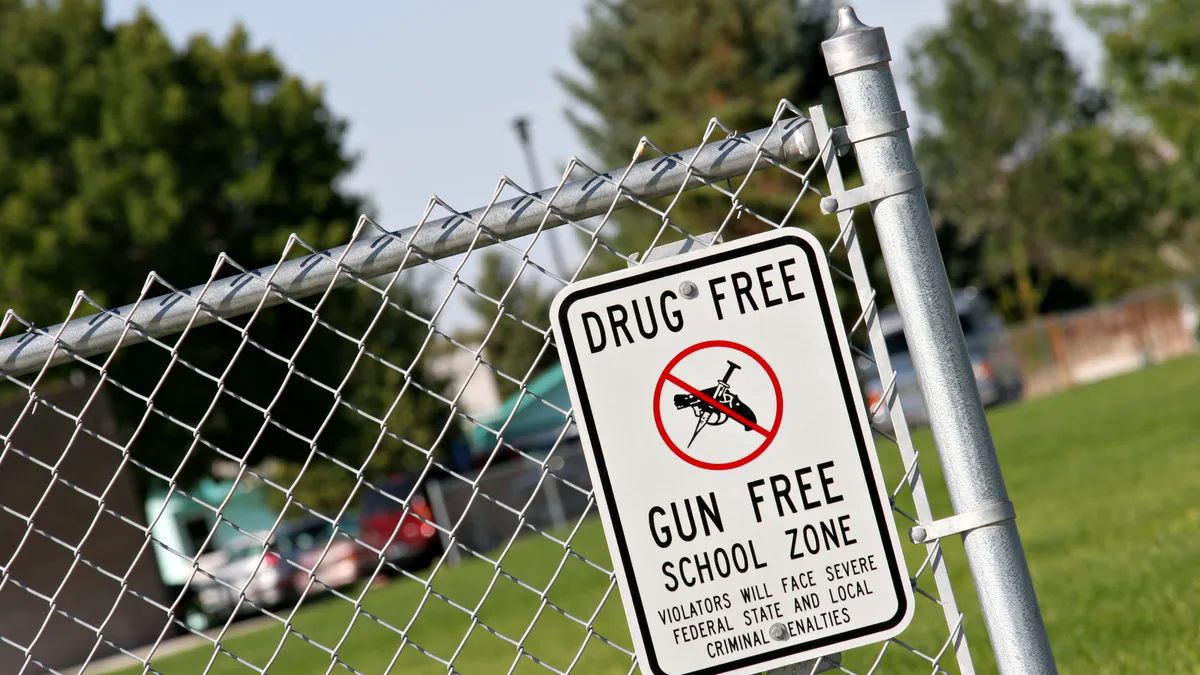 A drug-free and gun-free school zone sign at a school yard