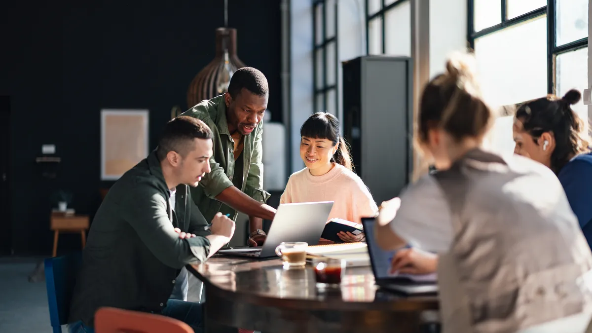 Young professionals collaborating in a bright, contemporary co-working environment, displaying teamwork and productivity.