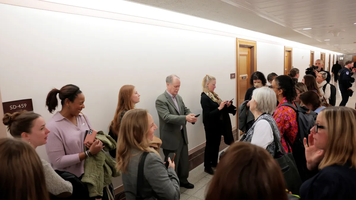 Individuals gather in a hallway.