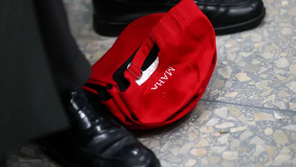 A hat with the acronym "MAHA" is seen on the floor.