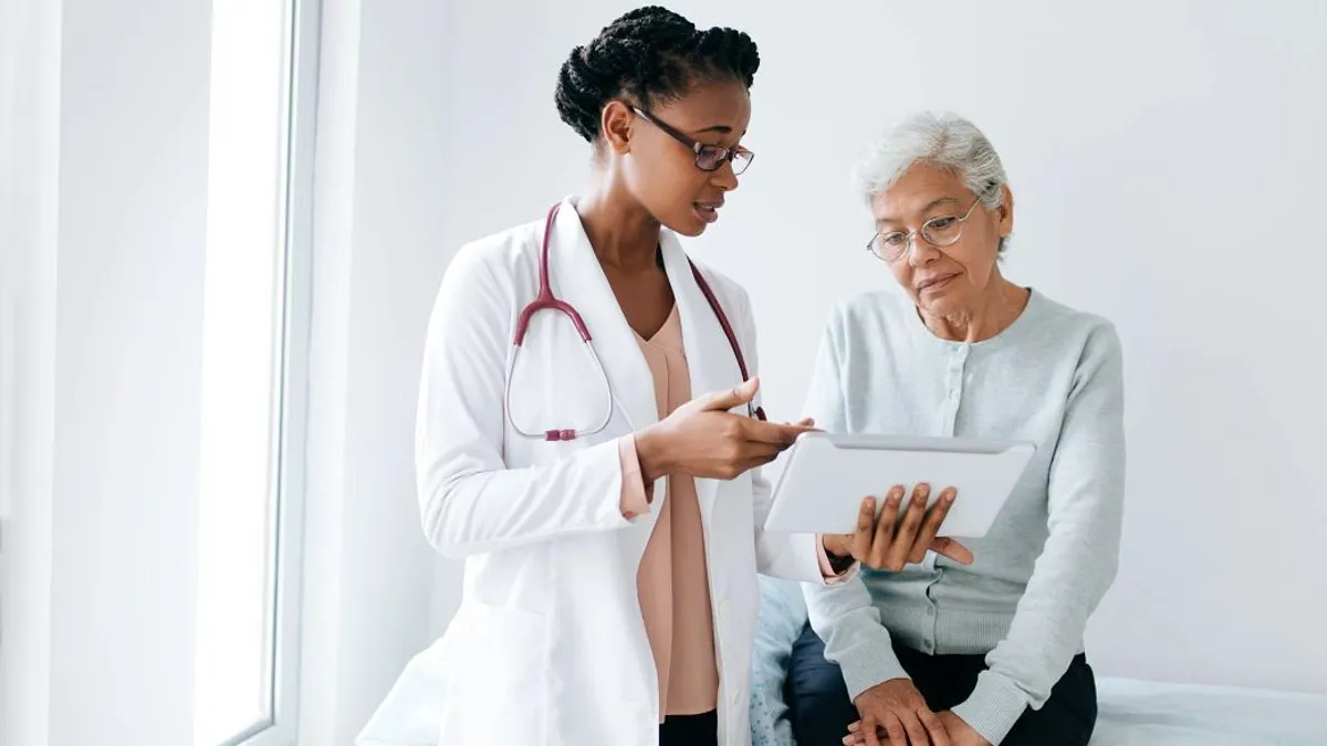 Doctor with tablet talking to patient