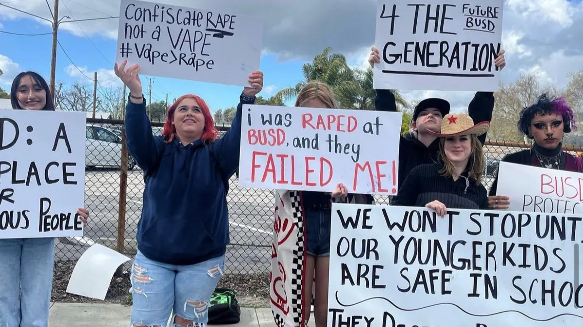 Students hold protest signs