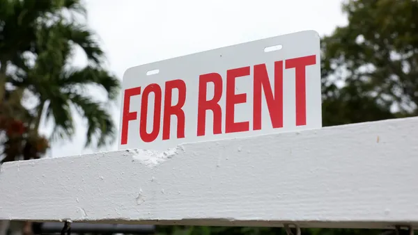 A "for rent" sign is posted in front of a home.