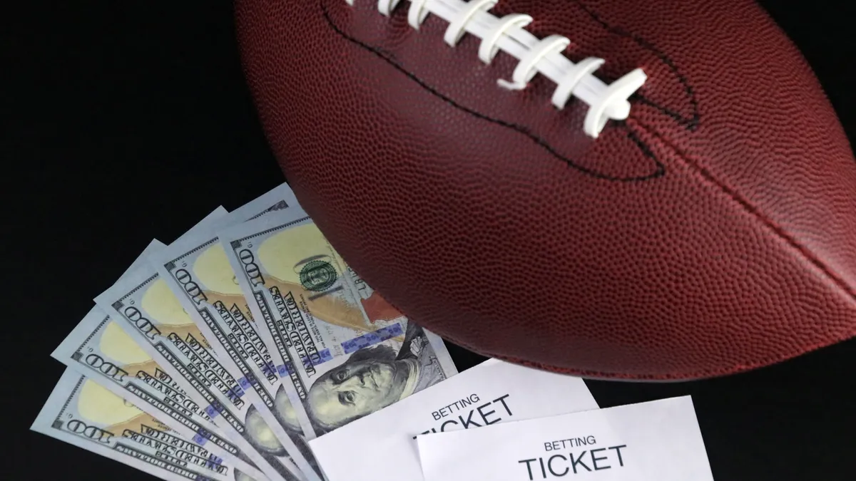 Betting tickets and cash sit next to a football.