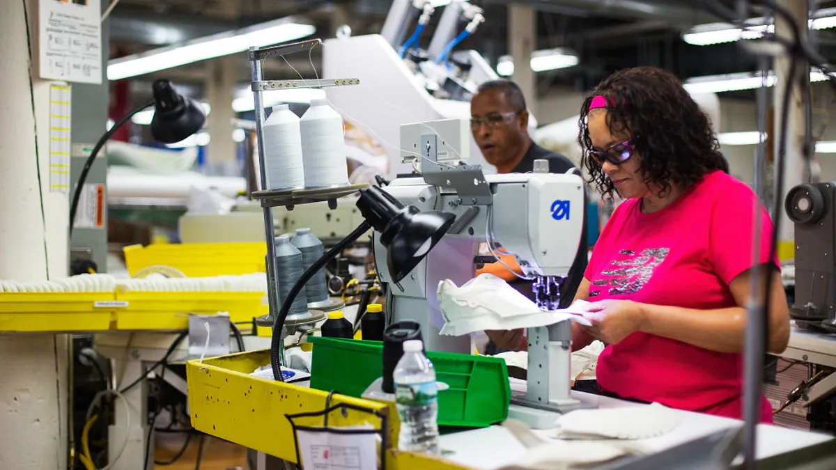 Workers manufacturer shoes in a factory.