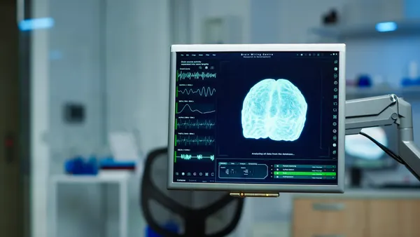 A brain scan is seen on a computer screen in an empty medical laboratory.